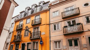 A multi-story building with balconies, a blue directional sign, and a door with a number. - Central & Typical Lisboa by GT House (Lisbon)