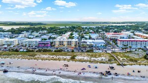 A coastal town with a beach, buildings, and a clear sky. - Beach Baby! Steps to South beach, Pool Access (Tybee Island)