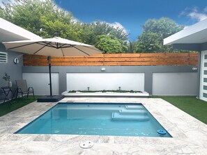A swimming pool with a wooden deck and a pergola.