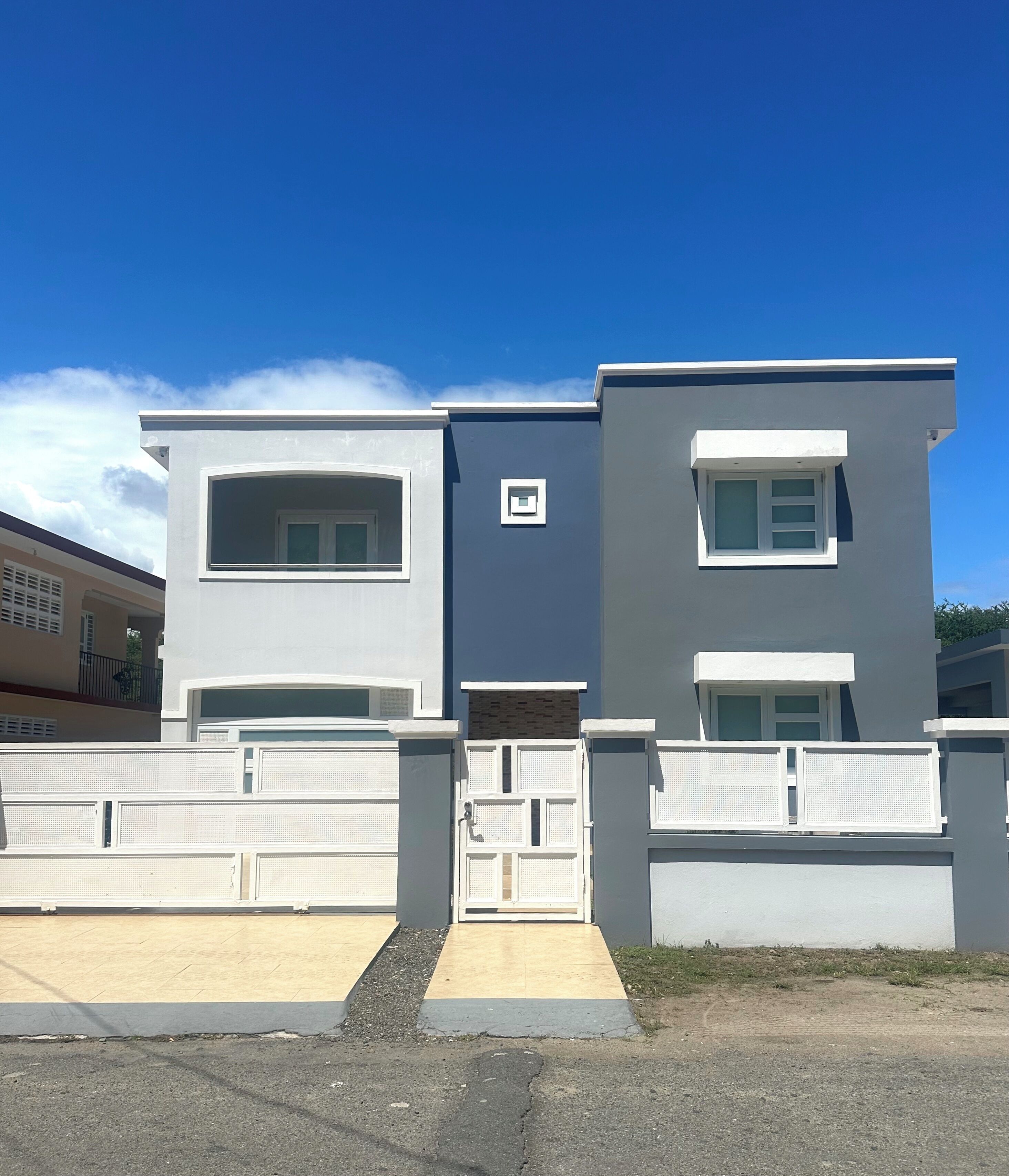 Un bâtiment moderne à deux étages, doté d’une façade grise, de grandes fenêtres et d’une entrée sécurisée par un portail.