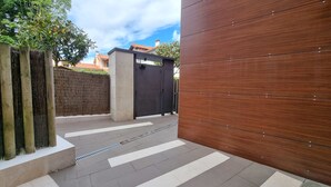 Una entrada protegida con un portón metálico y una valla de madera.