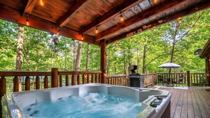 A hot tub on a wooden deck with a view of a forest. - Seclusion! I Privacy I Fire Pit I Game Room I Arcades I Pet Friendly I Hot Tub (Sevierville)