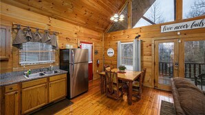 A wooden cabin interior with a kitchen, dining area, and a cozy seating area. - Seclusion! I Privacy I Fire Pit I Game Room I Arcades I Pet Friendly I Hot Tub (Sevierville)