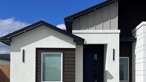 Una moderna casa a un piano con garage, ingresso e un piccolo portico.