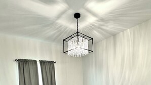 Una sala da pranzo con un tavolo in legno scuro, quattro sedie e un lampadario.