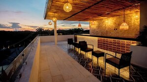 An outdoor patio with a bar area, seating, and hanging lights. - Luxury Penthouse with Private Pool in Tulum by BT Homes (Tulum)
