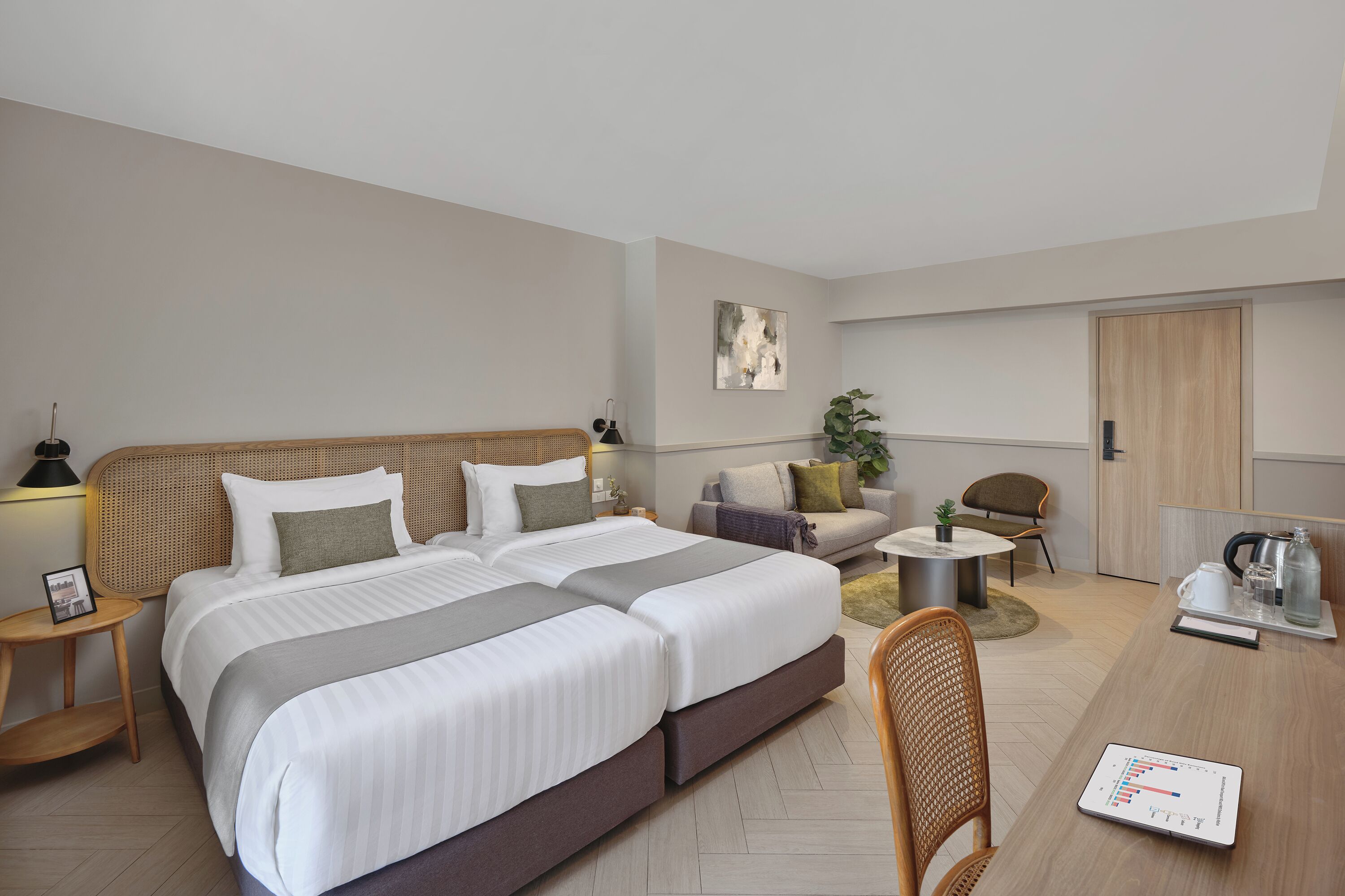 A modern hotel room with a large bed, a desk, a chair, and a small table.