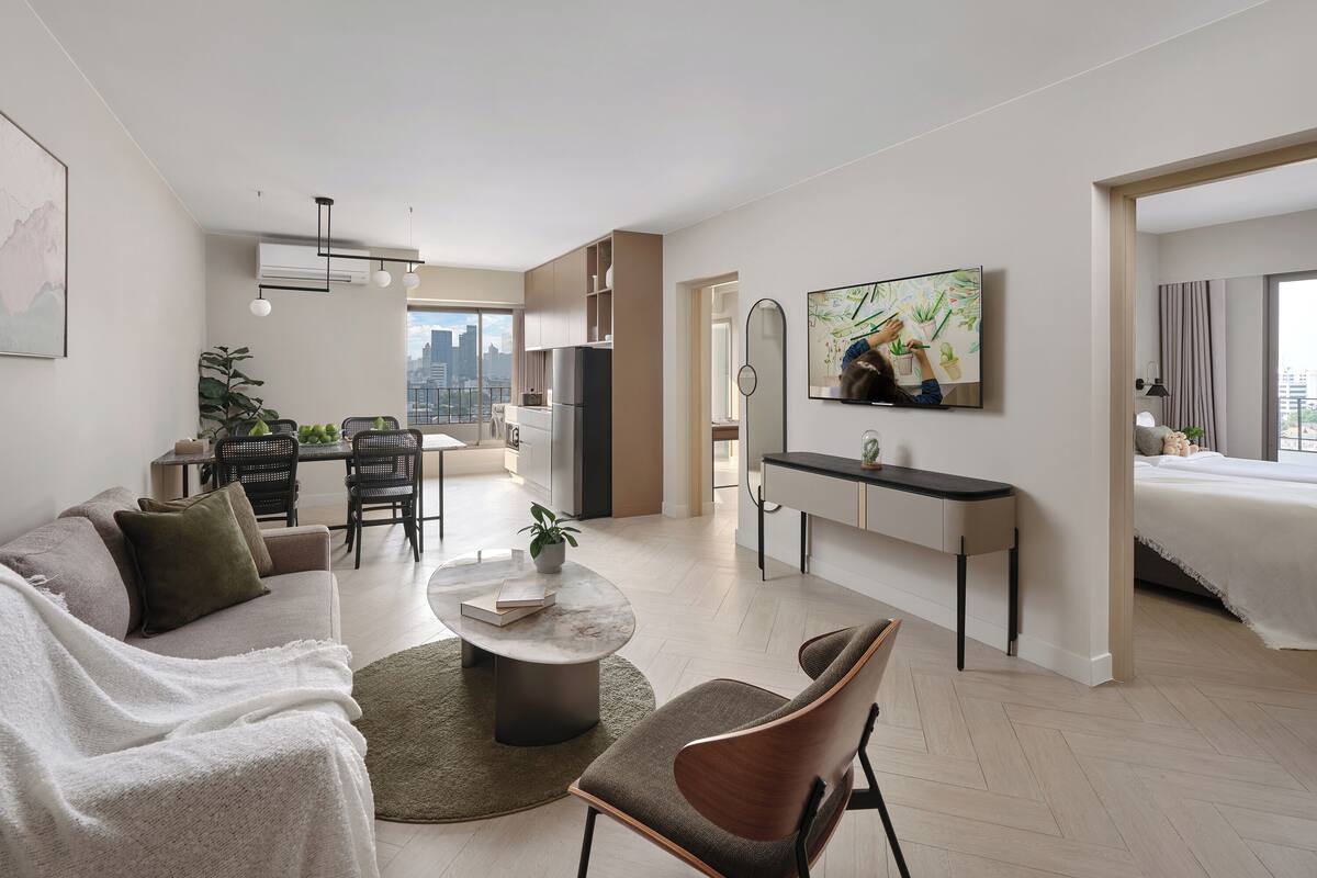 Una sala moderna con un sofá, una mesa de centro y un comedor con sillas y una mesa.