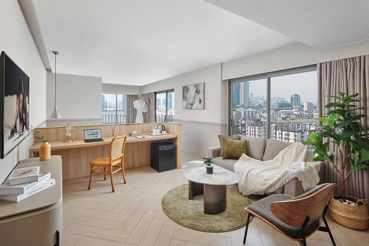 Una sala de estar moderna con vista a la ciudad, un comedor y una pequeña cocina.