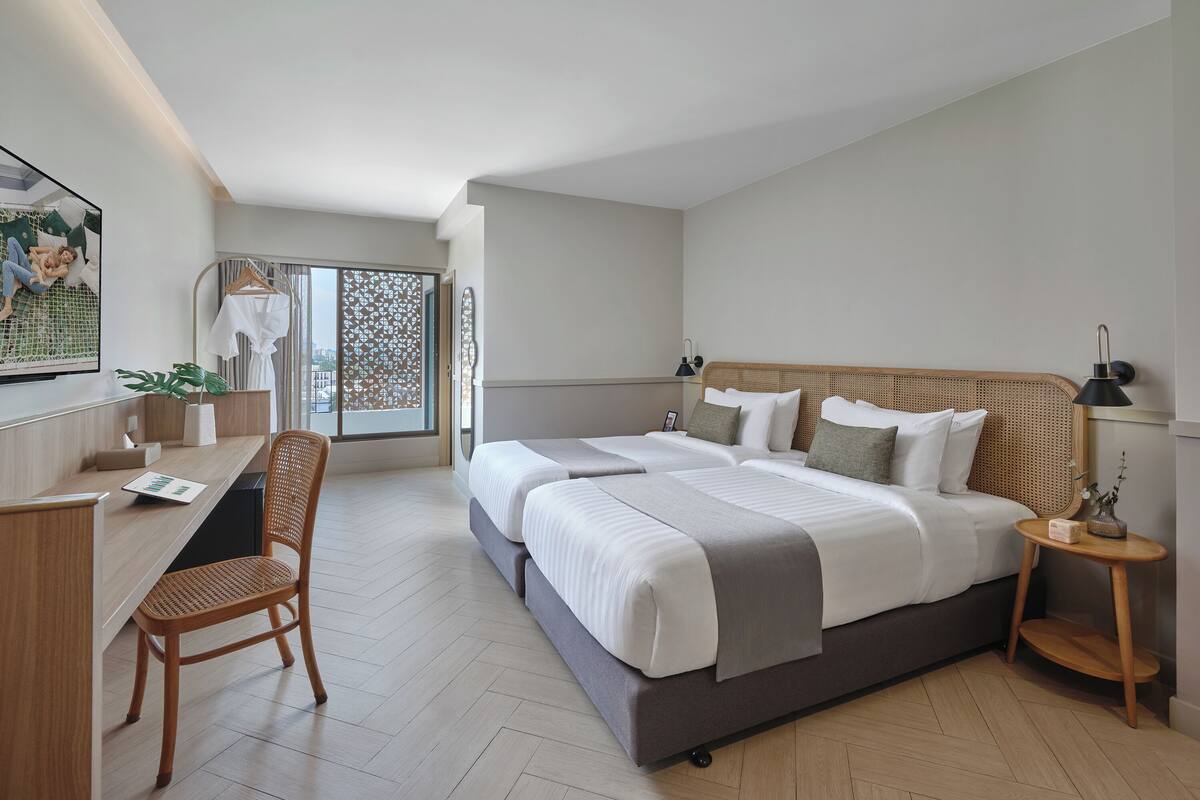 Una habitación de hotel moderna con una cama grande, un escritorio y una silla.