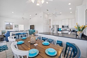 Enjoy meals in the well-appointed kitchen and dining area, featuring a central island and comfortable seating.