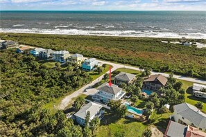 Stunning ocean views surround homes nestled among lush greenery.