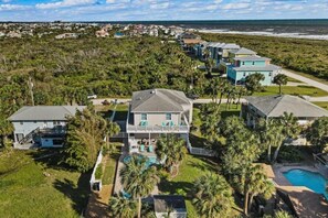 A coastal residential area with houses, a swimming pool, and a view of the ocean. - Beach Arcade - Palm Coast, Florida 4 Bedroom Home (Palm Coast)