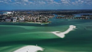 An aerial view of a coastal city with a prominent marina, dense urban area, and a large sandy beach. - Gulf-view Condo With Resort-style Amenities 2 Bedroom Condo (Marco Island)