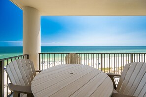 Un balcone con tavolo e sedie che si affaccia su una spiaggia.