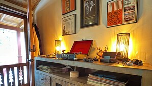 Ein Holzinterieur mit einem Schreibtisch, Regalen und gerahmten Bildern an der Wand.