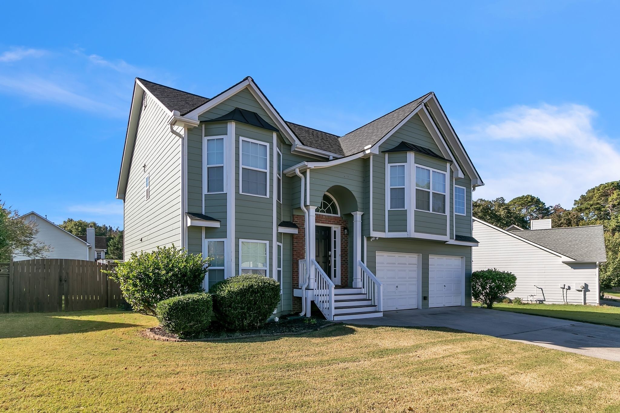 A two-story house with a front porch, a garage, and a well-maintained lawn.