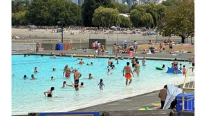 A swimming pool area with people swimming and sunbathing, a fence, and a sign that reads 'KITSILANO'. - Private Garden Suite Close to UBC, Airport & Downtown (Vancouver)
