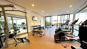 A gym with cardio equipment, weight machines, and dumbbells. - Exclusive Solaria Arch View Penthouse with Jacuzzi (Cabo San Lucas)