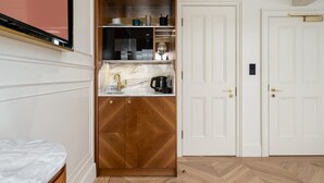 A compact kitchen with a built-in microwave, Bosch coffee maker, and a sink with a gold faucet. - GuestReady – Top Floor Central London Getaway (London)