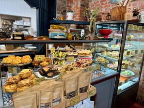 A bakery display case with various baked goods and pastries. - The Mackinnon (Carterton)