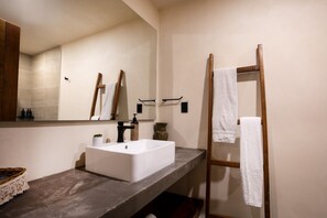 A bathroom with a large mirror, a white sink, and a wooden towel rack. - Luxury Penthouse w/ Jungle Views (Tulum Municipality)