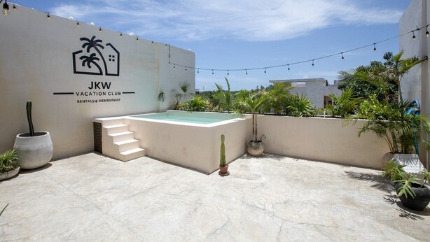 Eine Dachterrasse mit Swimmingpool, einer Treppe und einem Schild für JKW Vacation Club Rentals & Membership.