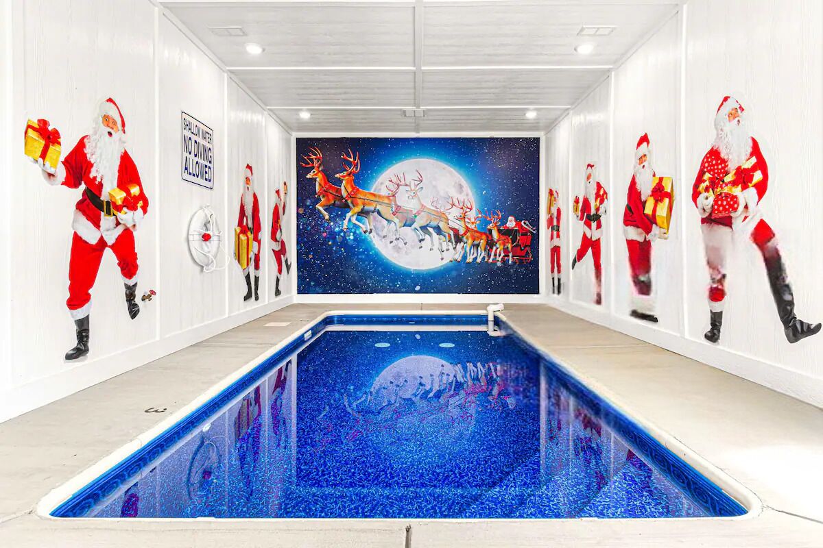 A swimming pool with a mural of Santa Claus and reindeer on the walls.