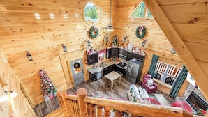 A wooden cabin interior with a kitchen, dining area, and a staircase. - XmasCabins by SmokyStays - Christmas Themed Year Round (Pigeon Forge)