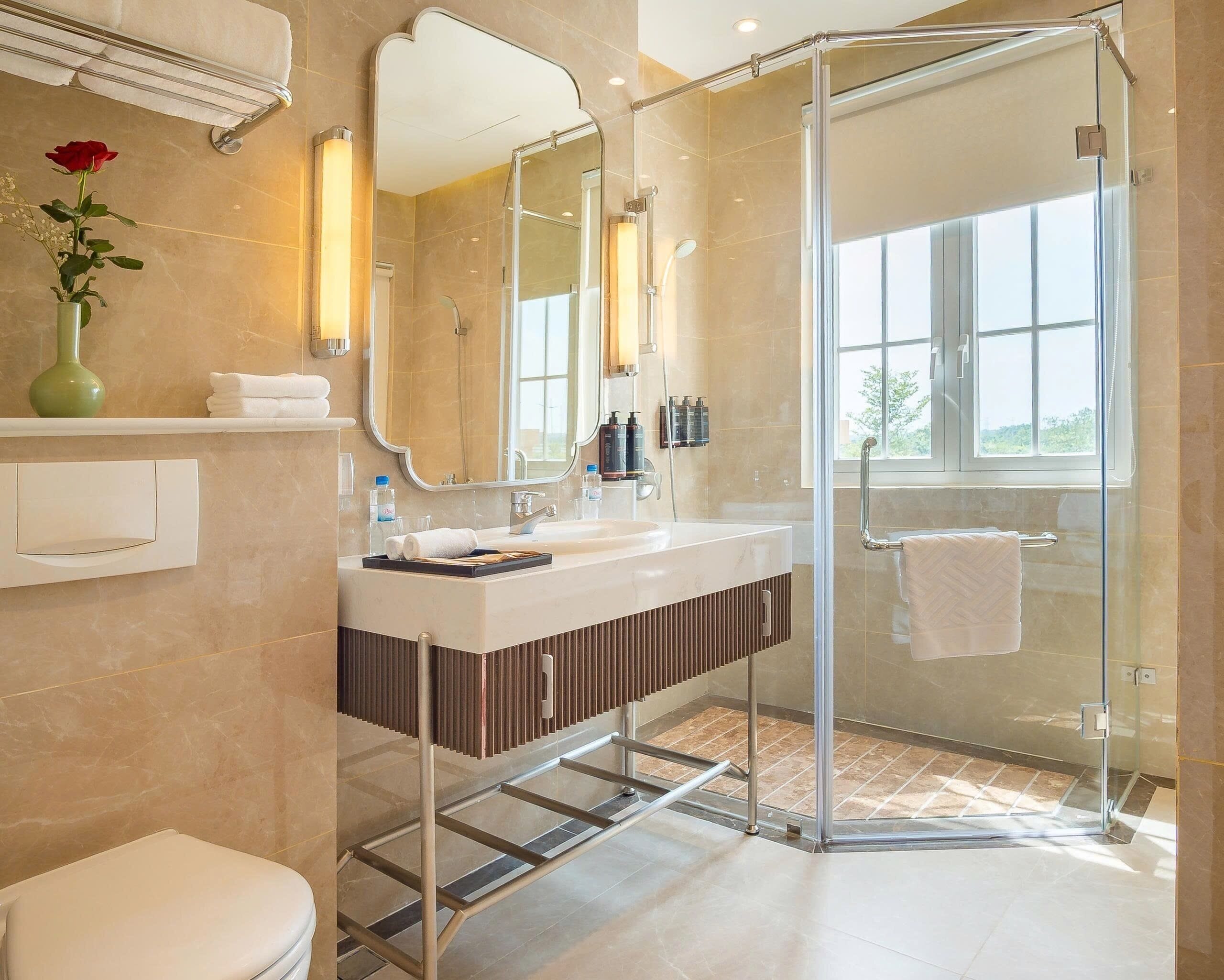 A modern bathroom with a glass shower enclosure, a vanity with a mirror, and a toilet.