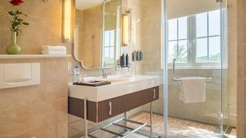 A modern bathroom with a glass shower enclosure, a vanity with a mirror, and a toilet.