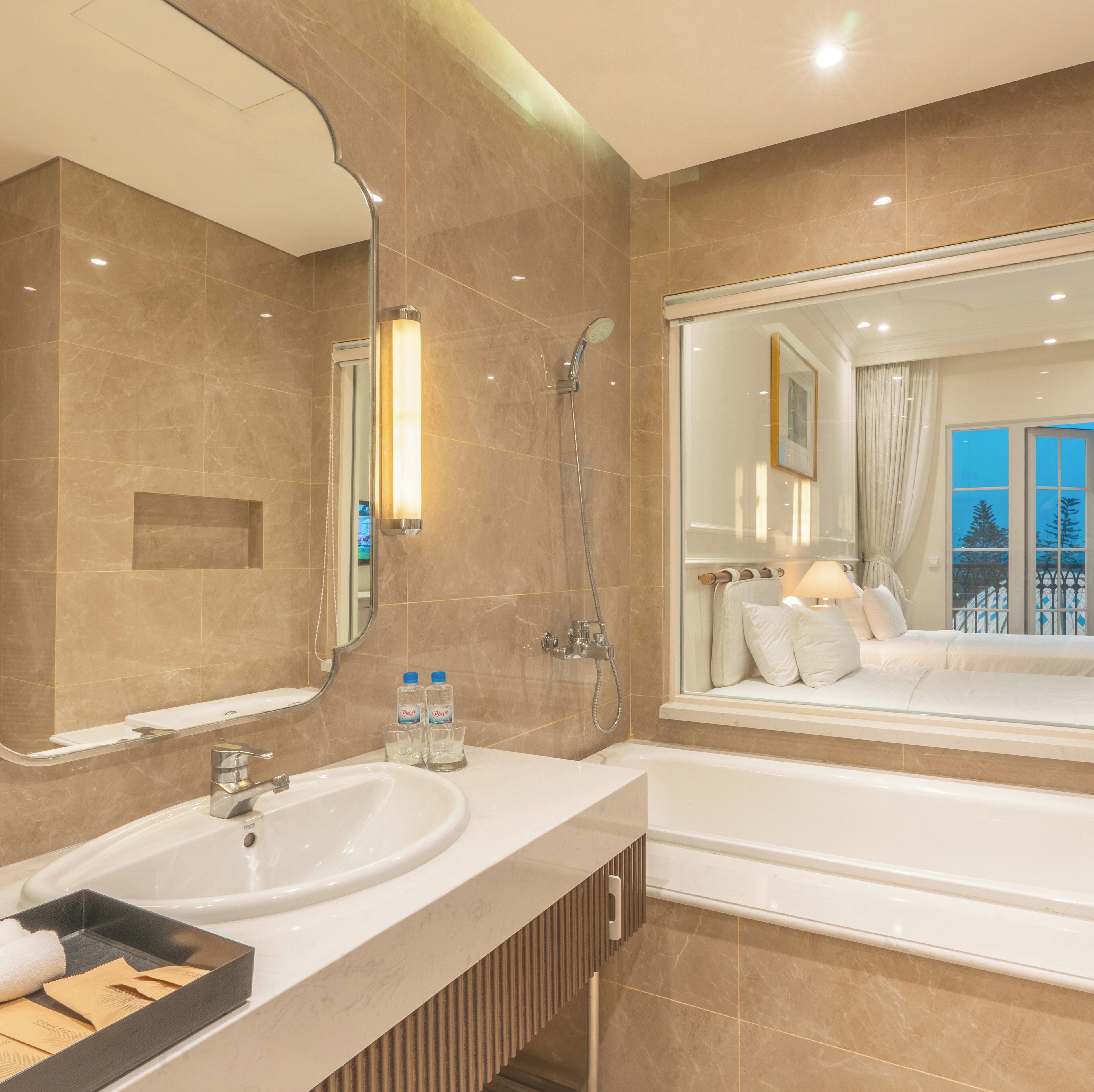 A modern bathroom with a large mirror, a bathtub, and a shower.