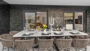 A dining area with a marble table, six wicker chairs, and a candelabra. - 6 bedroom stunning home in Podglavica (Podglavica)