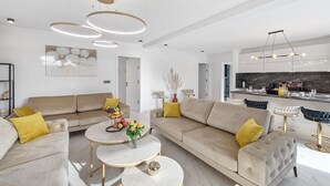 A modern living room with a sofa, coffee table, and decorative items. - 6 bedroom stunning home in Podglavica (Podglavica)