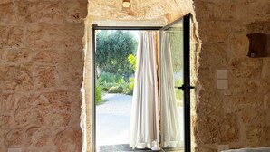 Una habitación con paredes de piedra y una puerta que da a un espacio al aire libre.