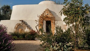 Un edificio con cúpula, un arco de piedra y un camino de grava.