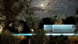 Un área de piscina moderna al aire libre con una mesa de billar minimalista y abundante vegetación.