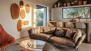 Una sala moderna con sofá, una mesa de centro y un comedor con sillas y una encimera de cocina.