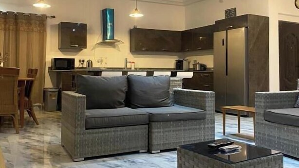 A modern living room with a sectional sofa, a coffee table, and a dining area with a table and chairs.
