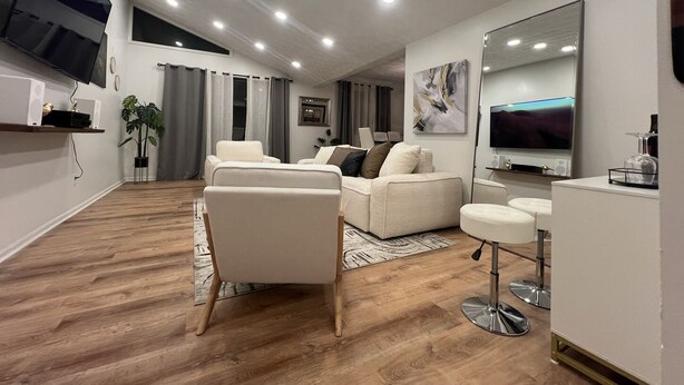 Una sala de estar moderna con un sofá, una mesa de centro y un televisor.