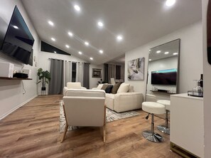 Un salon moderne avec un canapé, une table basse et un téléviseur.