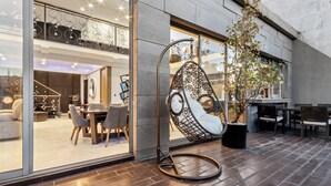 Ein modernes Interieur mit Hängekorbschaukel, Essbereich und großem Fenster.