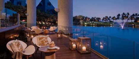 A luxurious outdoor seating area with a pool view, featuring modern furniture and ambient lighting.