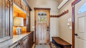 A wooden interior with a door, a bench, a coat rack, and a lamp. - Breckenridge Escape with Hot Tub & Mountain Views (Breckenridge)