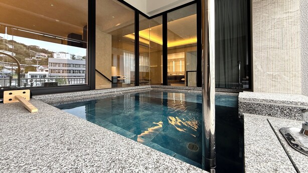 A modern indoor swimming pool with a clear view of the cityscape through large windows. - DOG HOTEL SHIRAHAMA (Shirahama)