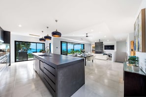 Una cucina moderna con isola centrale, ampie finestre e vista sull'esterno.