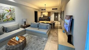A modern living room with a sofa, a coffee table, and a television.