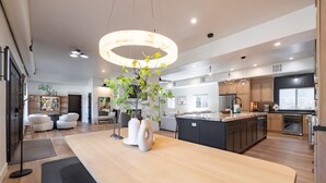 Une cuisine moderne dotée d’un îlot central, de meubles en bois et d’un luminaire suspendu.
