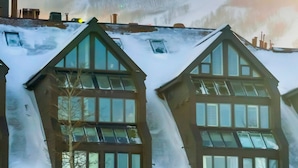 A building with steeply pitched roofs and multiple windows.