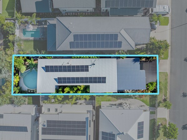 An aerial view of a residential area with modern houses, solar panels, and a swimming pool. - Nestled on Nautilus (Kingscliff)
